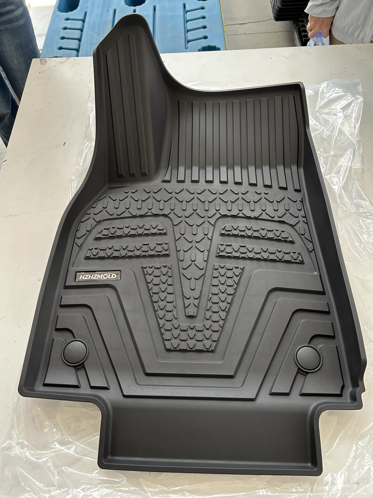 Actual HZHZMOLD floor mat sample showing molded surface details and logo badge
