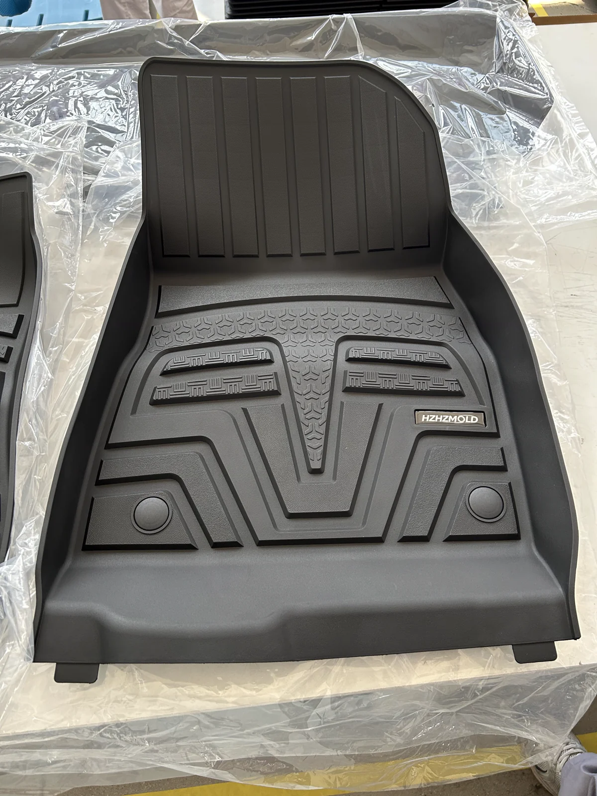 Actual HZHZMOLD molded floor mat showing raised edges and branded badge